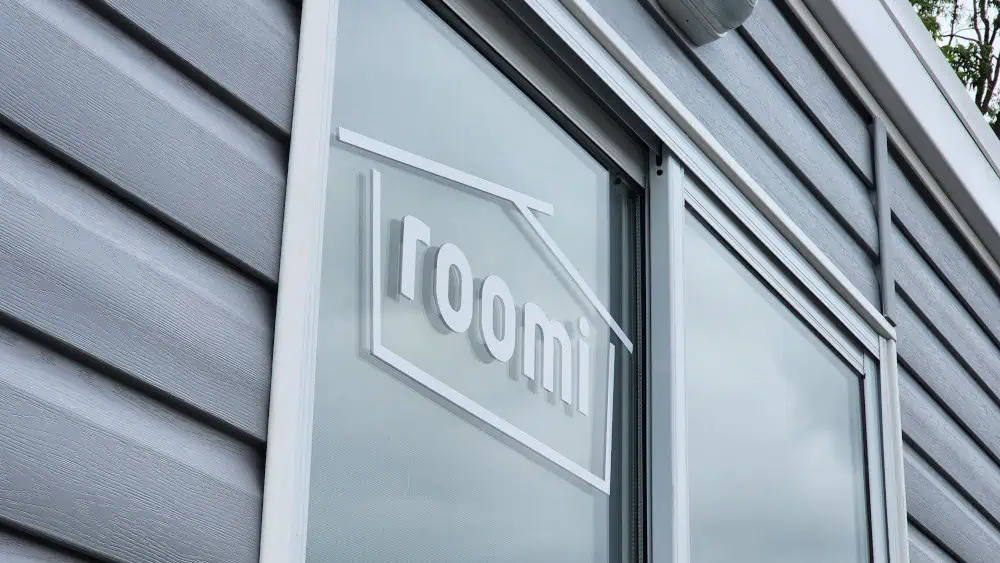 Close-up of the Roomi logo on the door of one of our transportable buildings